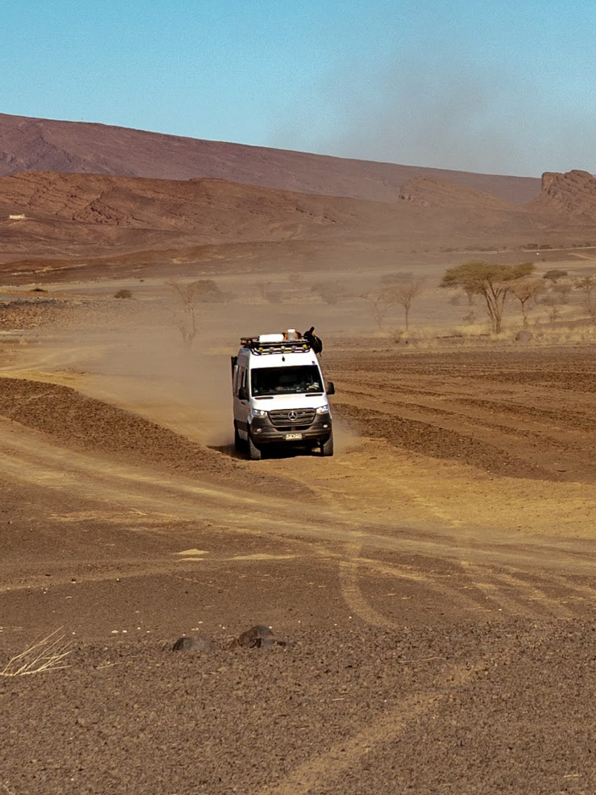 Mercedes Sprinter 4x4 camper driving on a dusty desert track