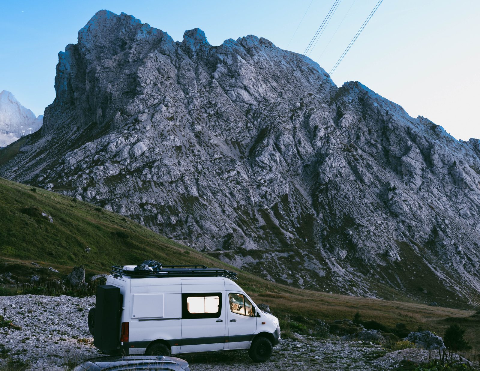 Mercedes Sprinter 4x4 camper on a mountain road at dusk