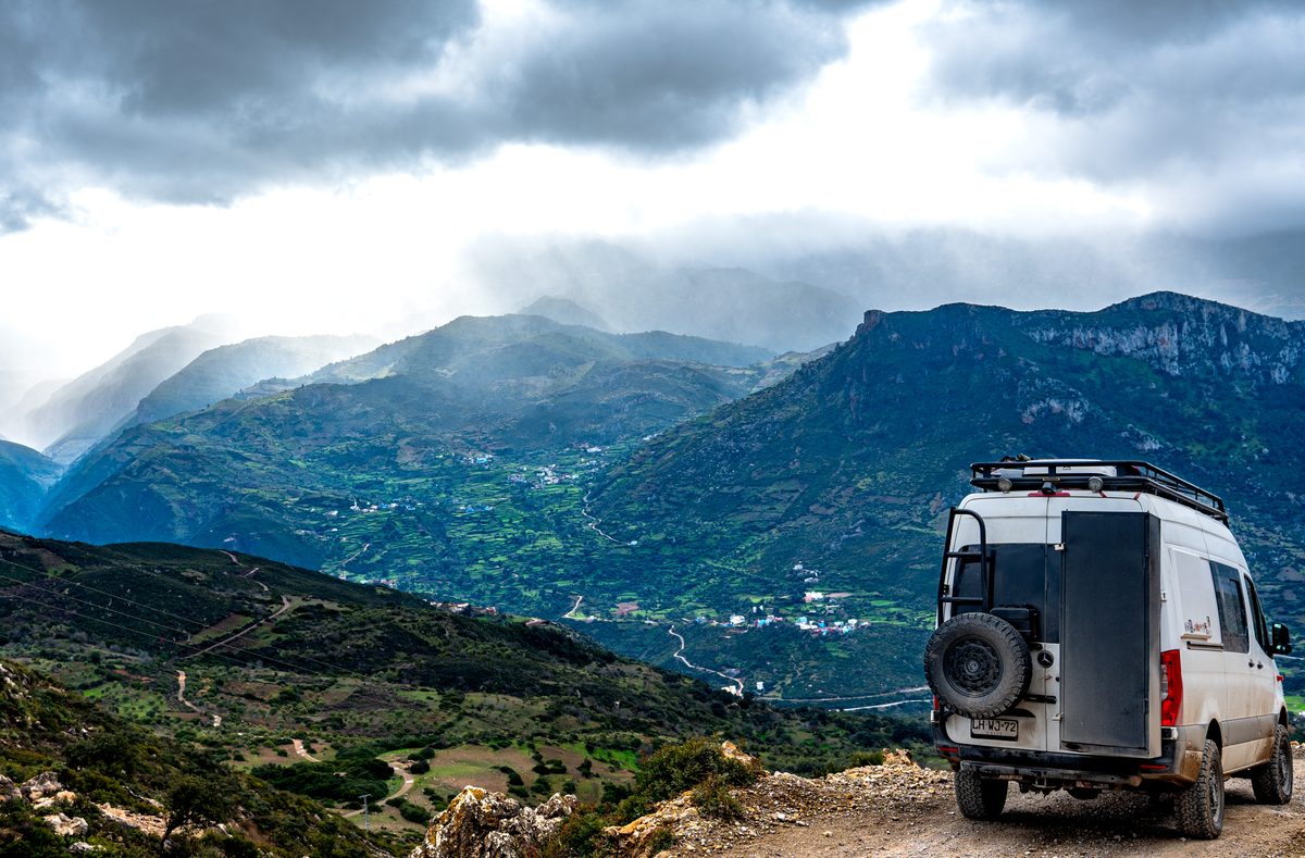 Mercedes Sprinter 4x4 camper on a mountain road overlooking a valley