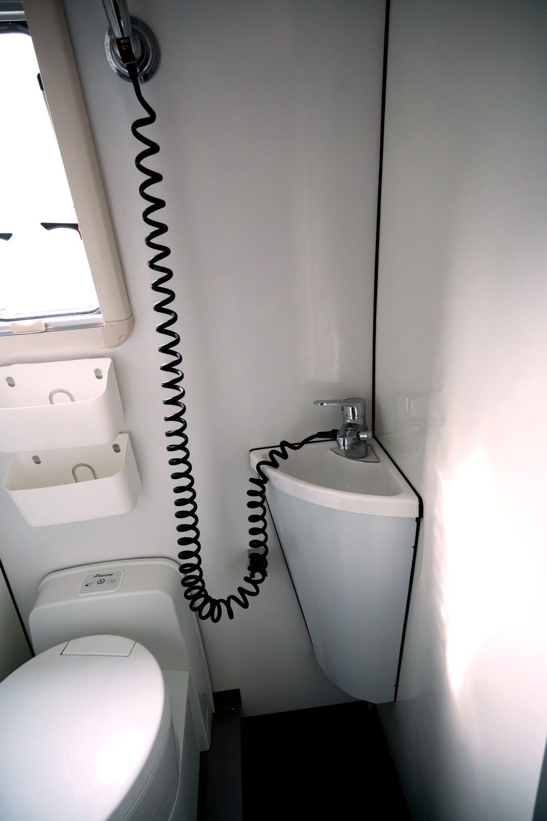 Corner bathroom sink and toilet inside the camper